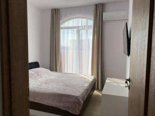 a small bedroom with a bed and a window at Apartament №1 in Villa Astoria 5 in Elenite