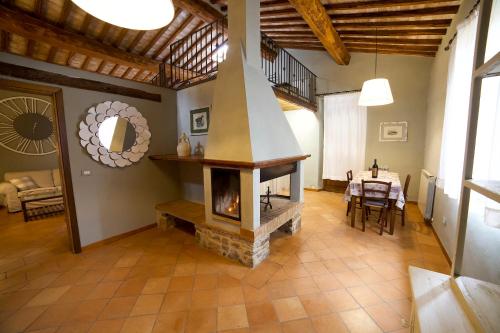 a living room with a fireplace and a table at Colle al Matrichese - Historic Winery in Montalcino