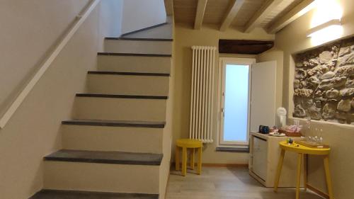 a staircase in a room with a table and two stools at Santa Marta Rooms - Vernazza in Vernazza