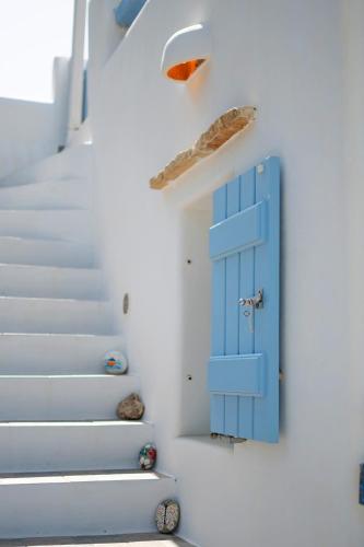 a blue door on a wall next to stairs at Molos Sea View House - Paros Greece in Molos Parou