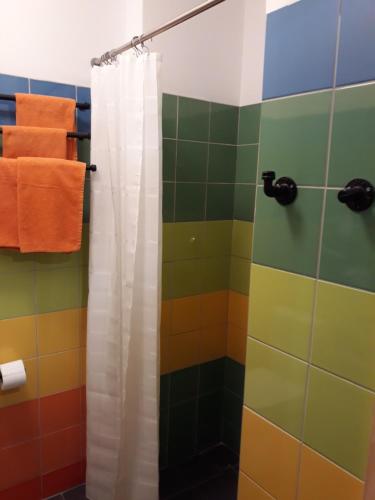 a colorful bathroom with a shower curtain and towels at Wioska pod Kogutem in Krępa