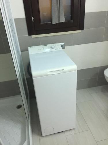 a white refrigerator in a bathroom with a mirror at La maison de Medea in Pulsano