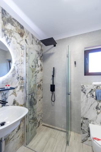 a bathroom with a shower and a sink at Kayus in Buşteni