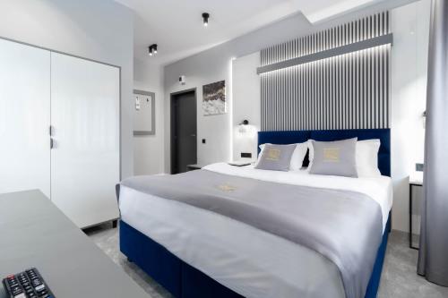 a bedroom with a large bed with a blue headboard at Kayus in Buşteni