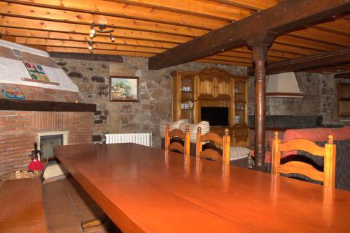 Una gran mesa de madera en una habitación con una pared de piedra. en La Casa de Consuelo 3, en Viérnoles