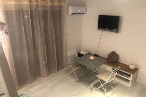 Cette petite chambre dispose d'une table et d'une télévision murale. dans l'établissement Apt With Swimming Pool 500m From The Beach, à Saint-Raphaël