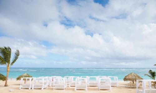 a row of white chairs on the beach at Majestic Mirage Punta Cana, All Suites – All Inclusive in Punta Cana