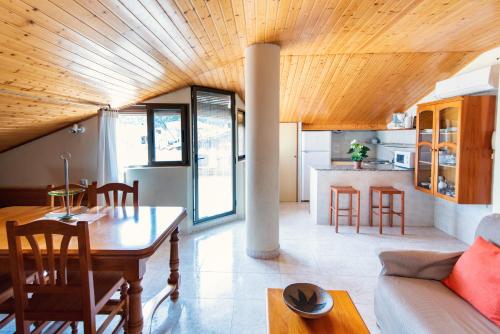 uma cozinha e sala de estar com tecto em madeira em Apartamentos Maribel em Calaceite