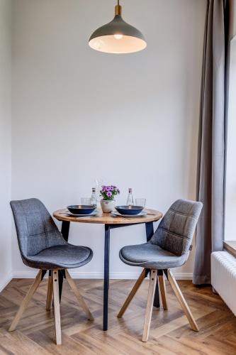 a dining room table with two chairs and a lamp at Design Pension Twenty 20 in Poděbrady