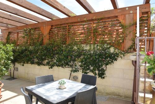 a patio with a table and some plants on a wall at Quei Trulli Divini in Martina Franca