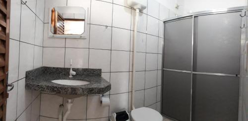 y baño con lavabo y ducha. en Pousada Jubaia, en Bonito