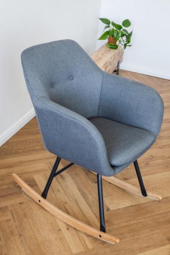 a blue chair sitting on a wooden floor at Design Pension Twenty 20 in Poděbrady