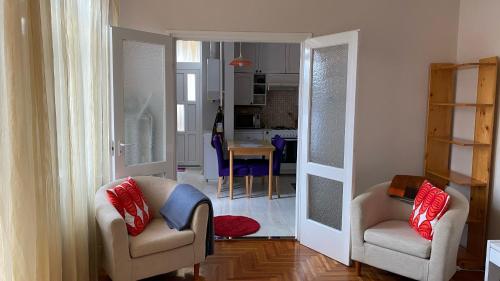 ein Wohnzimmer mit 2 Stühlen und eine Küche in der Unterkunft Balàzs Apartman in Eger