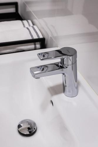 a bathroom sink with a chrome bathroom faucet at Design Pension Twenty 20 in Poděbrady