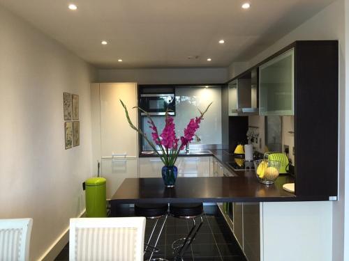 a kitchen with a vase of flowers on a counter at City Centre Luxurious Cambridge 2 Bed Apartment with Balcony, Lift, Free Parking, Fast WIFI & Sleeps 6 in Cambridge