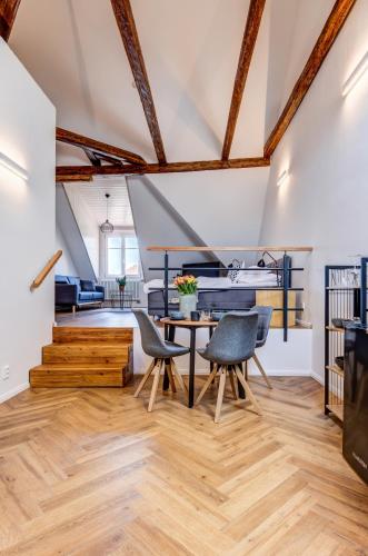 a living room with wooden floors and a table and chairs at Design Pension Twenty 20 in Poděbrady
