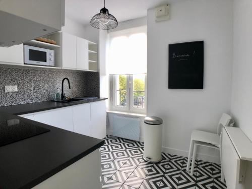 Il comprend une cuisine dotée de carrelage noir et blanc. dans l'établissement Superbe appartement rénové et tout confort à Brest, à Brest