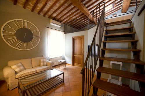 a living room with a couch and a spiral staircase at Colle al Matrichese - Historic Winery in Montalcino