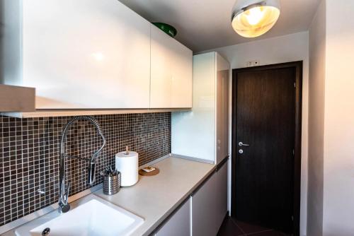 eine Küche mit einem Waschbecken und einer schwarzen Tür in der Unterkunft La Nueve Suite in Braşov