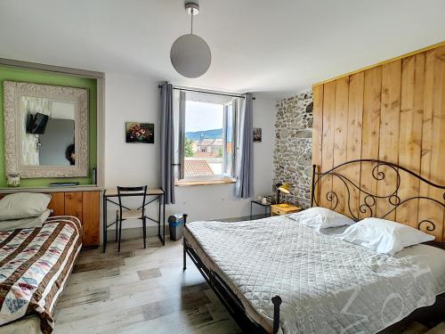 Schlafzimmer mit einem Bett, einem Spiegel und einem Fenster in der Unterkunft Maison de ville au pied de la Montagne Noire in Mazamet