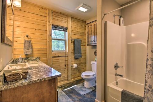 a bathroom with a toilet and a sink and a tub at RuKaRaSa Cabin with Yard and Dock at Grand Lake in Eucha