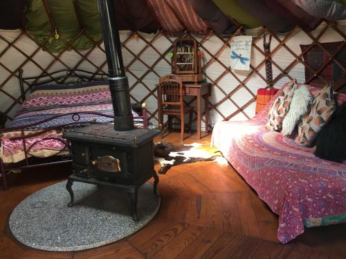 a room with a stove and a bed in a yurt at Star Gazing Luxury Yurt above beautiful RIVER, off grid in Vale do Barco