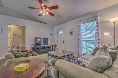 un soggiorno con divani e ventilatore a soffitto di Home 10 Mi to Downtown Pensacola Pets Welcome! a Pensacola