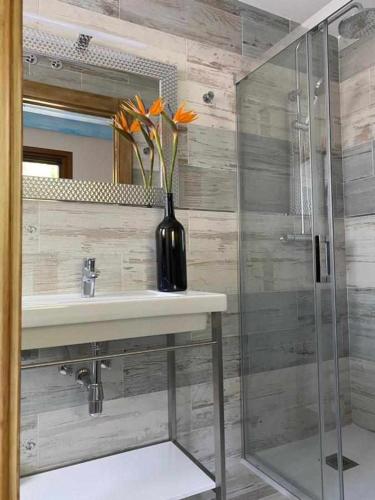 a bathroom with a sink and a vase with flowers in it at Casa Rural Mugarri in Poveña