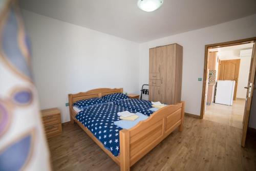 Schlafzimmer mit einem Bett mit blauer Decke in der Unterkunft House with pool in Mali Lošinj