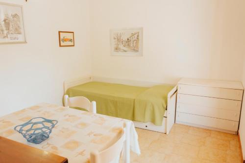 a bedroom with a table and a bed and a table and chairs at Residence Villa la Palmas in Porto Azzurro