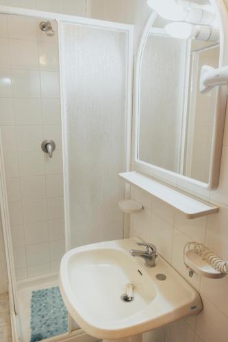 a white bathroom with a sink and a shower at Residence Villa la Palmas in Porto Azzurro