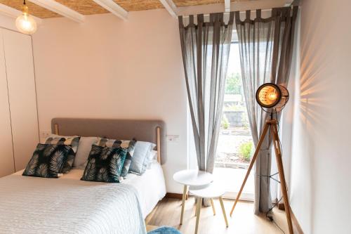 ein Schlafzimmer mit einem Bett und einer Uhr neben einem Fenster in der Unterkunft Casitas de Madera O Loureiro in Noya