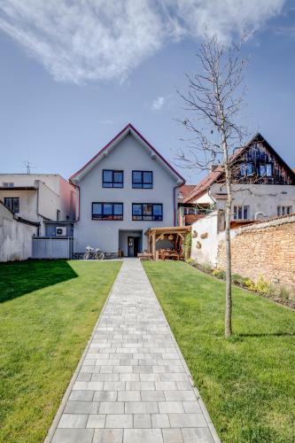 a white house with a tree in the yard at Design Pension Twenty 20 in Poděbrady