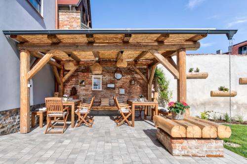 a wooden pergola with tables and chairs on a patio at Design Pension Twenty 20 in Poděbrady