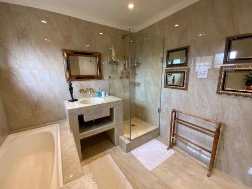 ein Badezimmer mit Dusche, Waschbecken und Badewanne in der Unterkunft Goblin's Mead in Edgemead