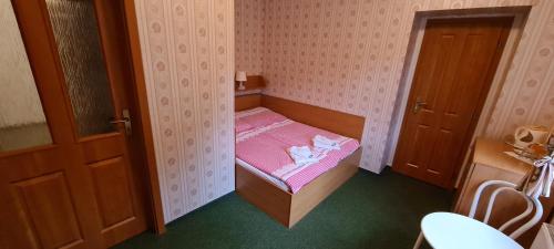 a small room with a small bed with pink sheets at Horské ubytování Královský dvůr na Bílém potoce in Hamry