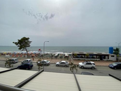 a parking lot next to a beach with cars parked at Milenium Hotel in Shëngjin