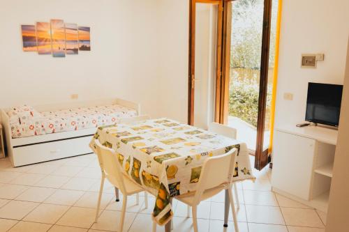 a dining room with a table and chairs and a bed at Hotel Villa Rosa in Porto Azzurro
