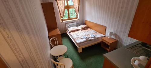 a small bedroom with a bed and a window at Královský dvůr Bílý potok in Hamry