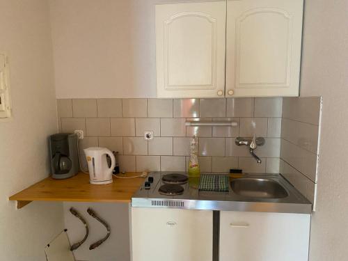 a small kitchen with a sink and a stove at Abigél Apartmanház in Balatonfüred