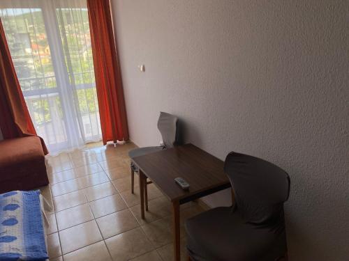 a room with a table and a chair and a laptop at Abigél Apartmanház in Balatonfüred