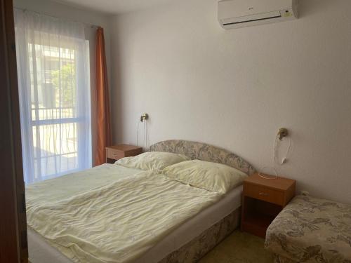a small bedroom with a bed and a window at Abigél Apartmanház in Balatonfüred