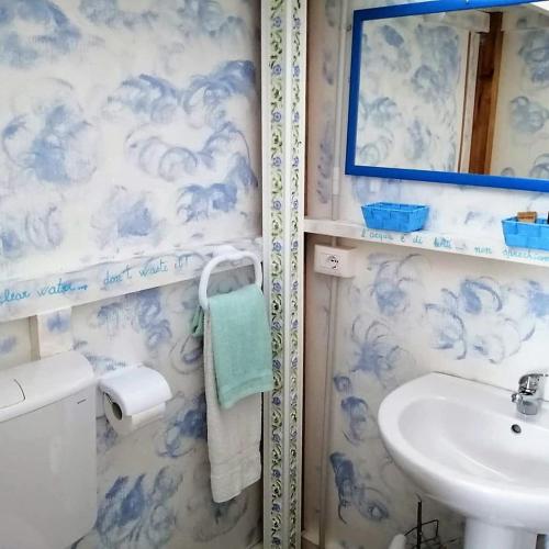a blue and white bathroom with a sink and a mirror at Agriturismo Glamping Erbe Matte in SantʼAntìoco