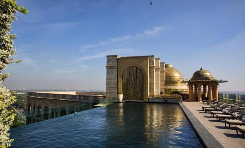a swimming pool on the roof of a building at The Leela Palace New Delhi in New Delhi