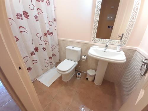 y baño con aseo, lavabo y espejo. en Biltmore ático luxury en San Miguel de Abona