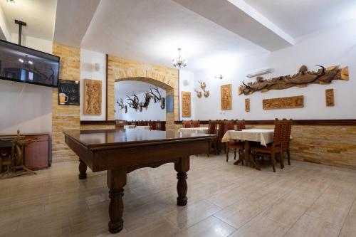 a room with a pool table and a dining room at Penzion Kamzik a Drevenica in Habovka