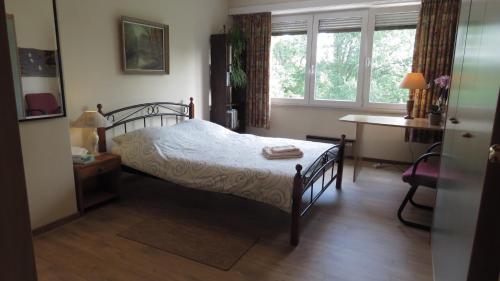 1 dormitorio con cama, escritorio y ventana en Prince d'Orange Bed & Breakfast, en Braine-lʼAlleud