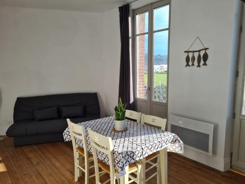 uma sala de estar com uma mesa e cadeiras e um sofá em La pause Mersoise em Mers-les-Bains