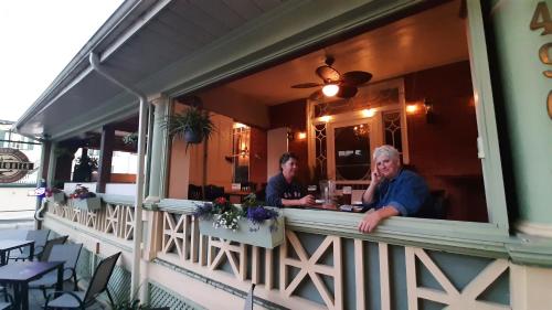 two men sitting at a table outside of a restaurant at Stonewater Manor B&B in Gananoque