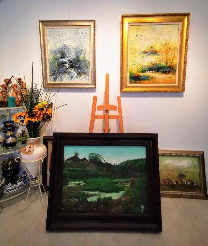 a framed painting in a room with paintings on the wall at Le Coin des Artistes in Giverny